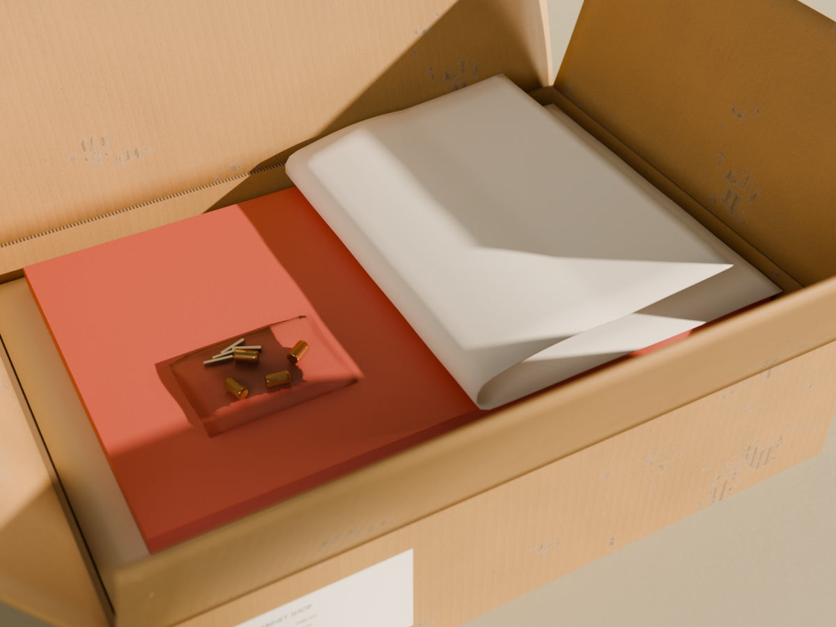 An opened delivery carton: a Terracotta cabinet door under peeled-back packing foam, with the brass knobs in a clear bag